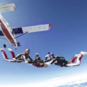 Saut d’initiation PAC à Gap Tallard avec deux moniteurs encadrant le participant à 4000 mètres d’altitude.